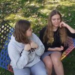 dwie dziewczynki siedzą na hamaku i rozmawiają