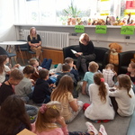 uczniowie klasy 2 PA siedzą na podłodze słuchając utworów czytanych przez nauczyciela
